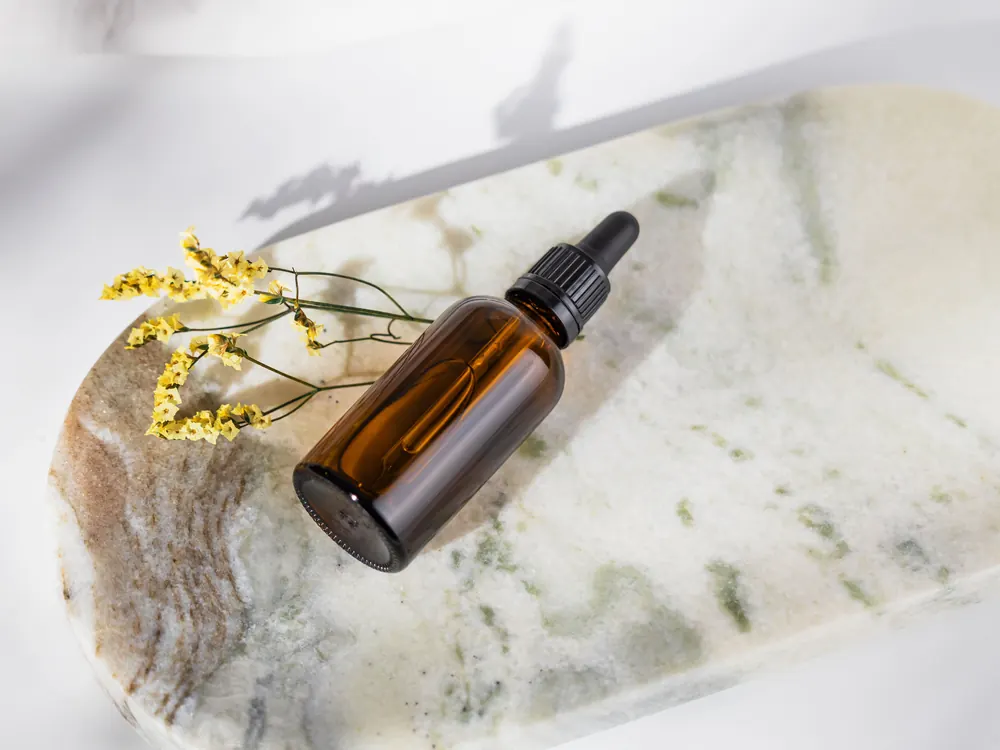 Amber dropper bottle of cold-pressed seed oil on stone