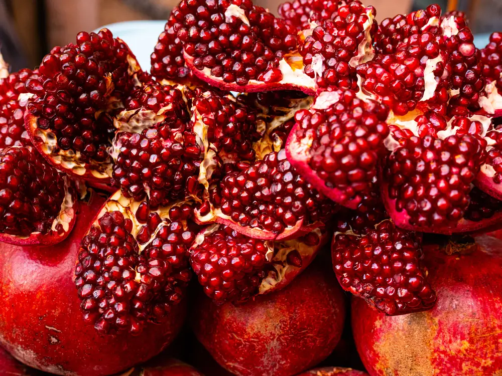 Ripe pomegranates split open to show the seeds