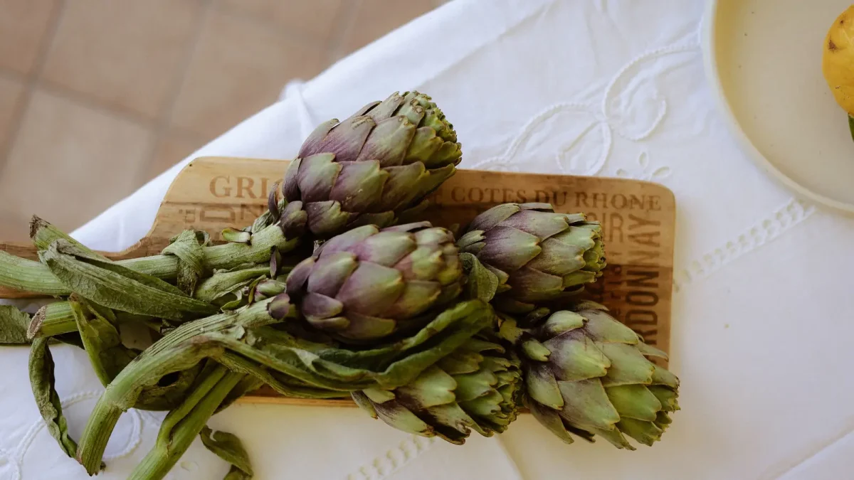 Artichokes with long stems on a board
