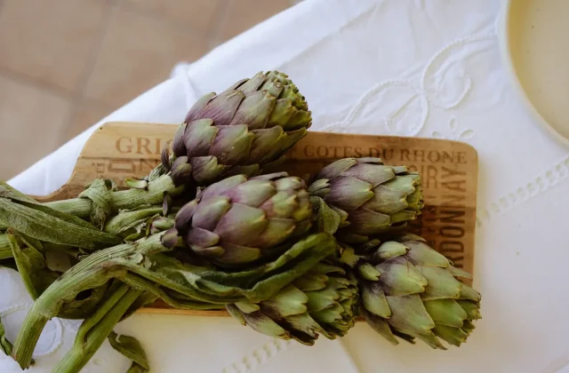 Artichokes with long stems on a board