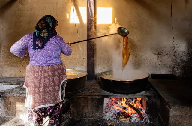 Carob syrup being reduced in a traditional cauldron