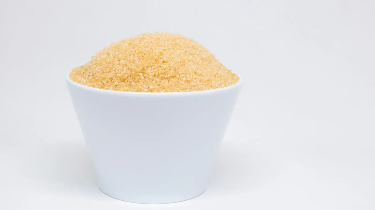 A white bowl of golden date sugar