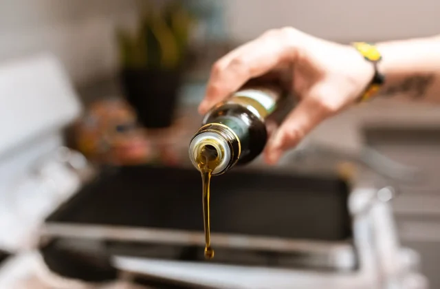 Extra virgin olive oil poured from a dark bottle