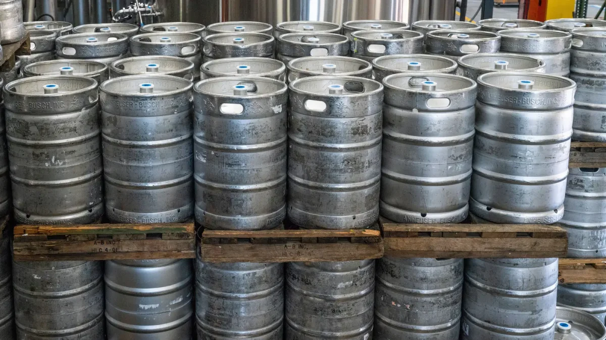 Steel drums of bulk liquid stacked on pallets in a warehouse