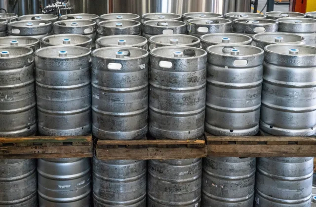 Steel drums of bulk liquid stacked on pallets in a warehouse