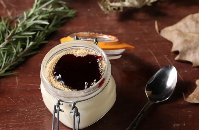 A jar of dark pomegranate jam with rosemary