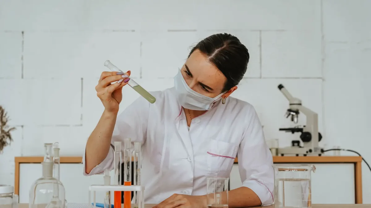 A technician examining a sample at a laboratory bench